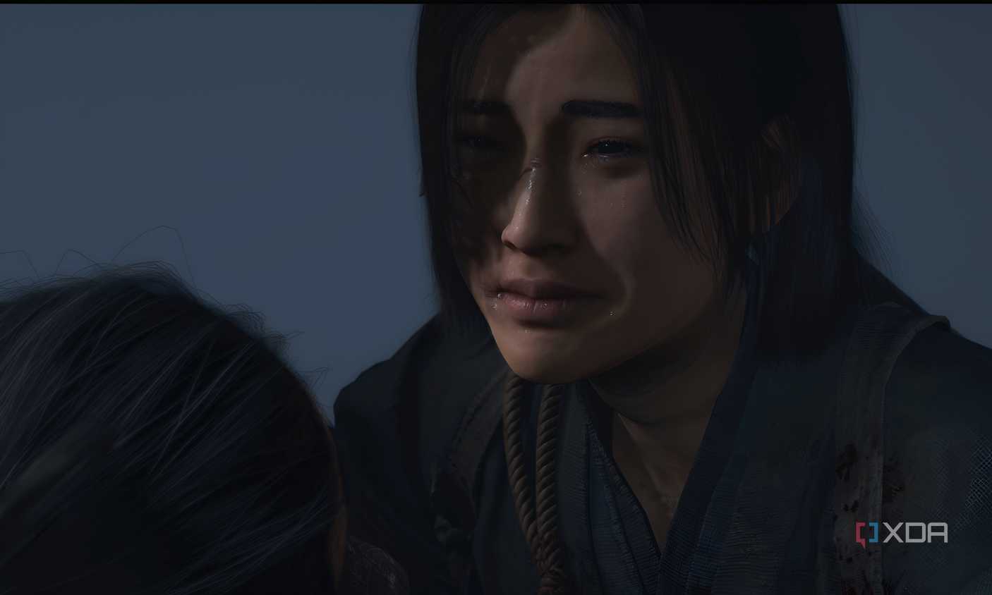 A screenshot from Assassin's Creed Shadows, showing the female protagonist crying.