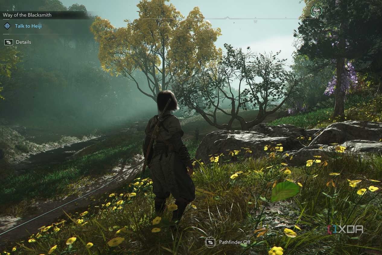 A screenshot from Assassin's Creed Shadows, showing Naoe, the protagonist, standing while surrounded by foliage.