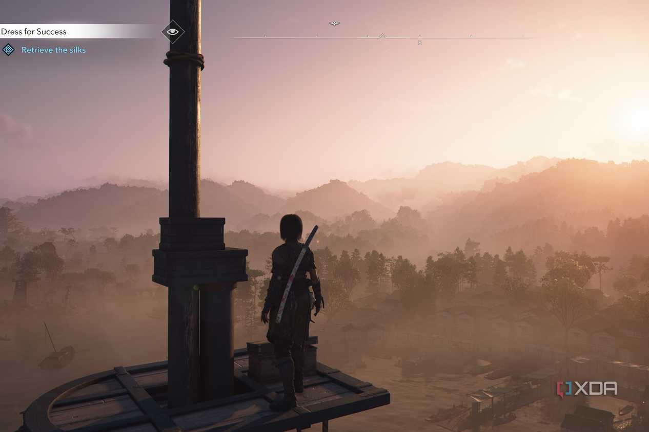 A screenshot from Assassin's Creed Shadows, showing Naoe, the protagonist, standing atop a high point, looking at a mist-shrouded mountainside.