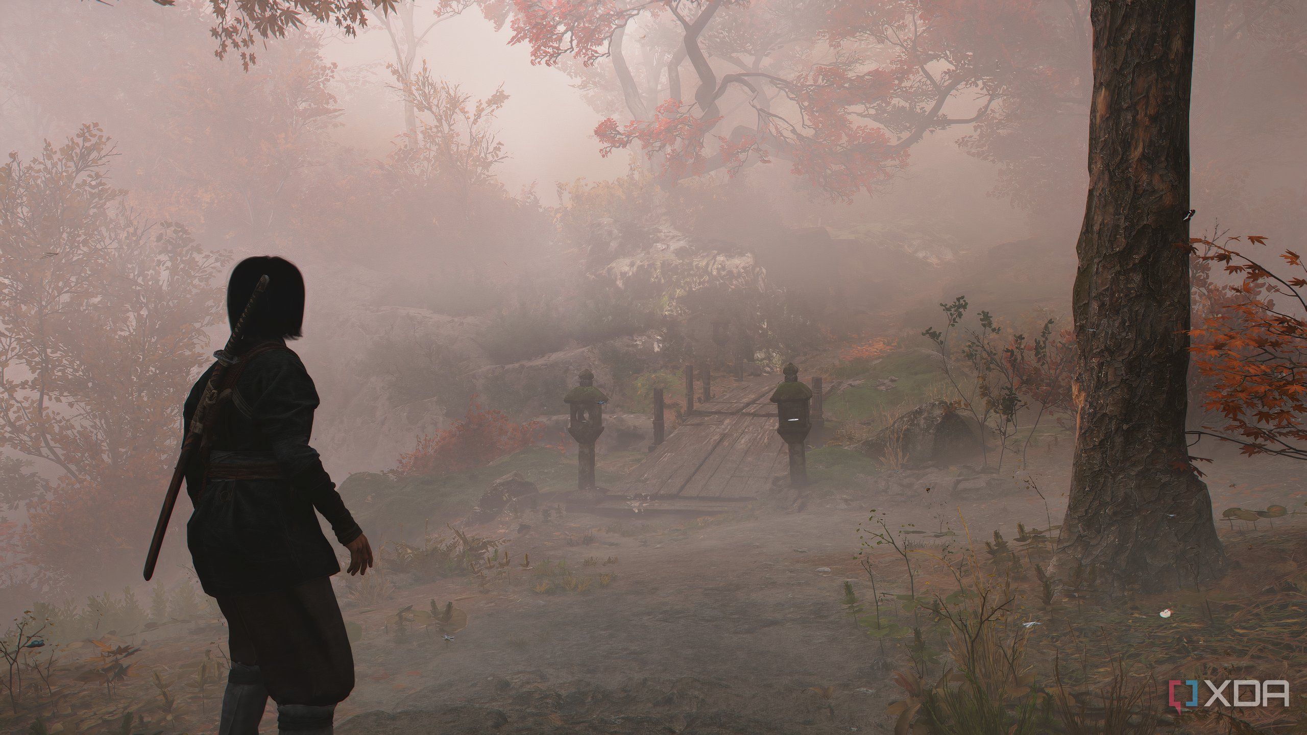 A screenshot from Assassin's Creed Shadows, showing Naoe walking down a mist-covered mountain trail.