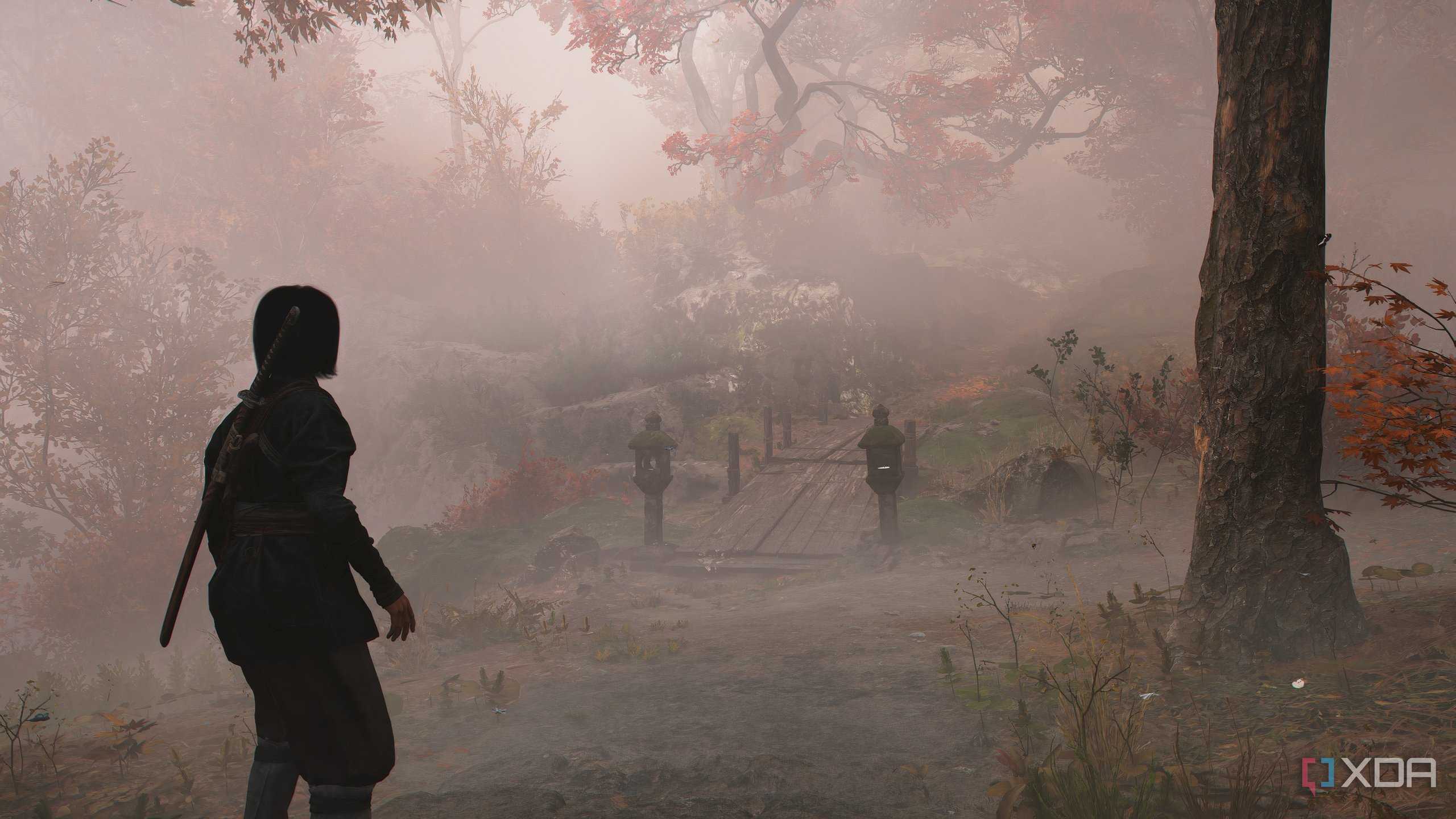 A screenshot from Assassin's Creed Shadows, showing Naoe walking down a mist-covered mountain trail.