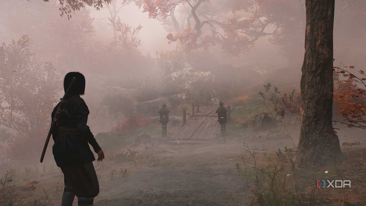 A screenshot from Assassin's Creed Shadows, showing Naoe walking down a mist-covered mountain trail.