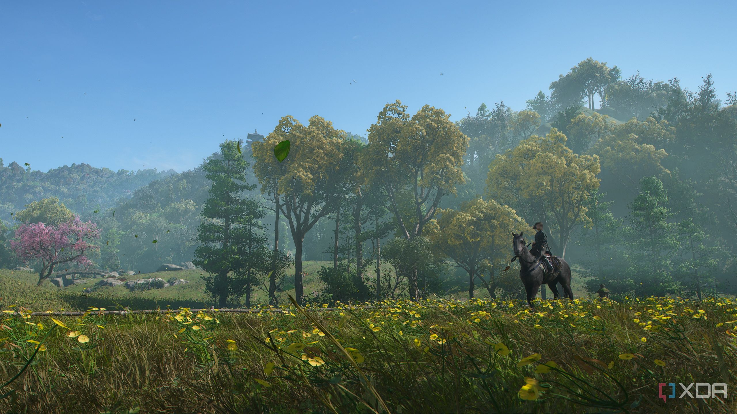 A screenshot from Assassin's Creed Shadows, showing Naoe, the female protagonist, sitting on horseback in a field of flowers and grass.
