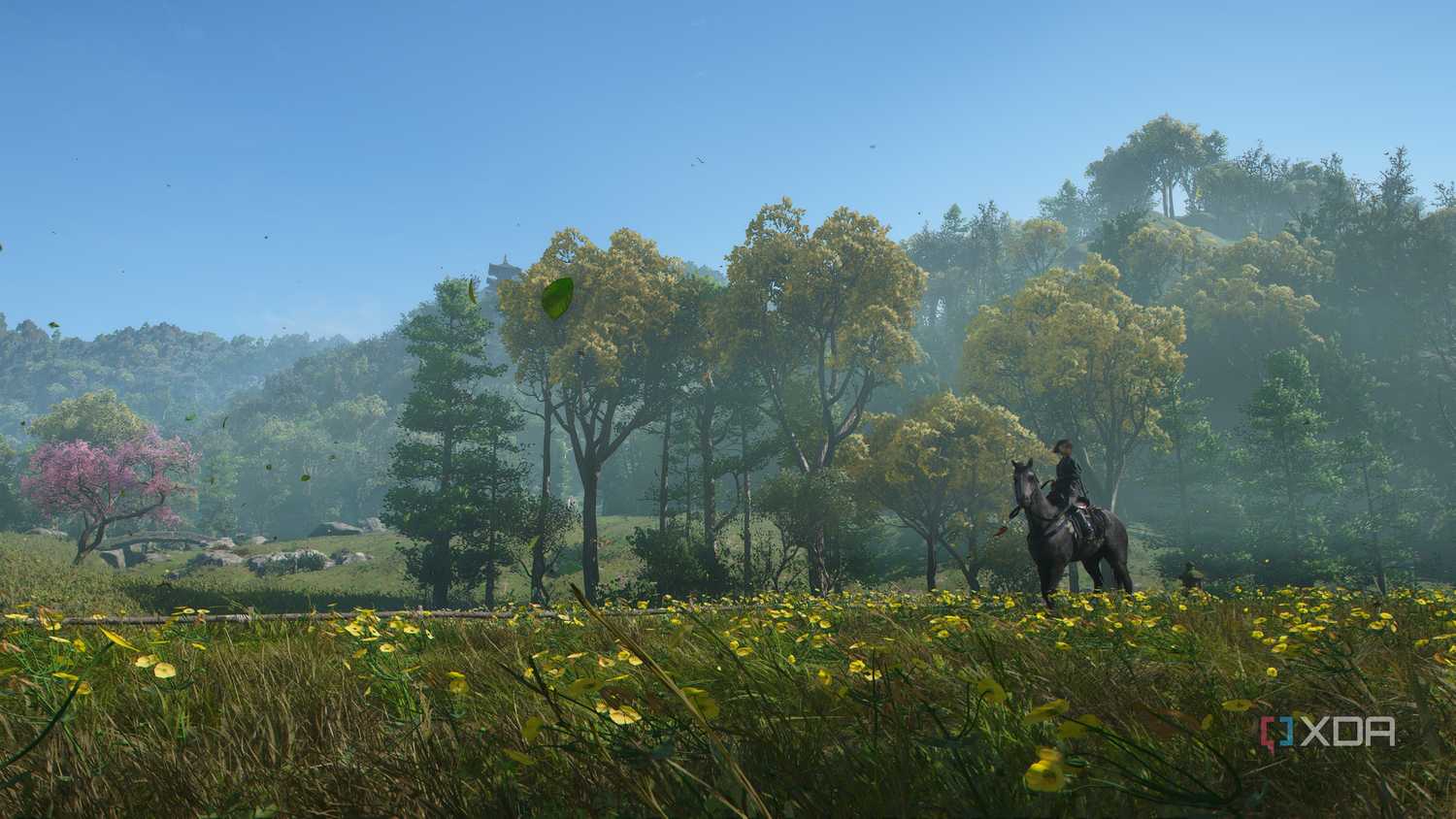 A screenshot from Assassin's Creed Shadows, showing Naoe, the female protagonist, sitting on horseback in a field of flowers and grass.