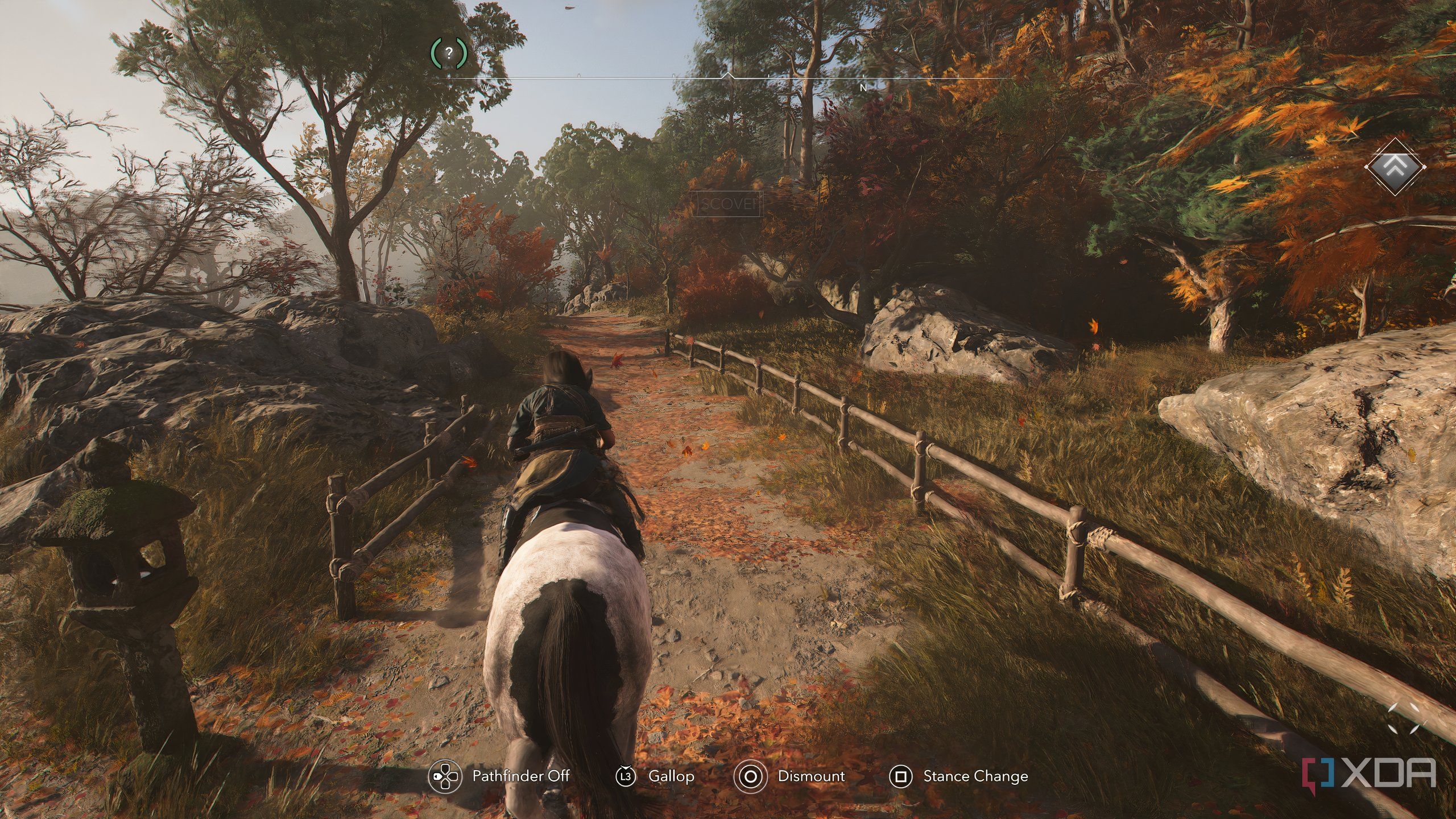 A screenshot from Assassin's Creed Shadows, showing Naoe riding on horseback down a windy mountain trail.