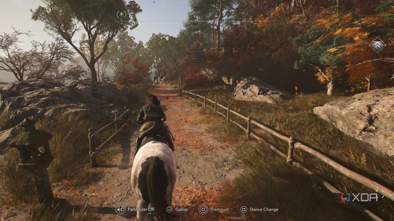 A screenshot from Assassin's Creed Shadows, showing Naoe riding on horseback down a windy mountain trail.