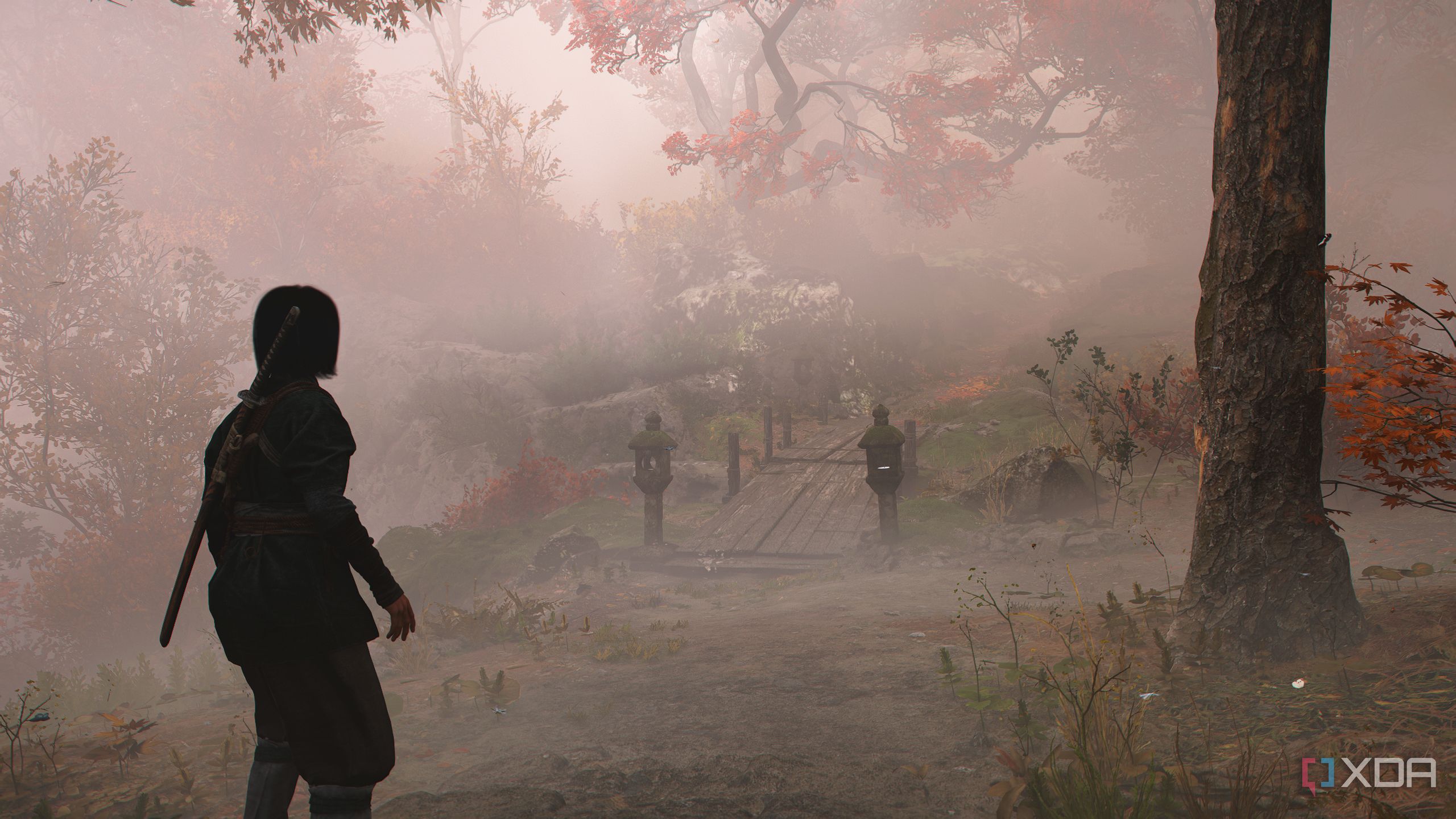 A screenshot from Assassin's Creed Shadows, showing a mist-covered mountain trail.