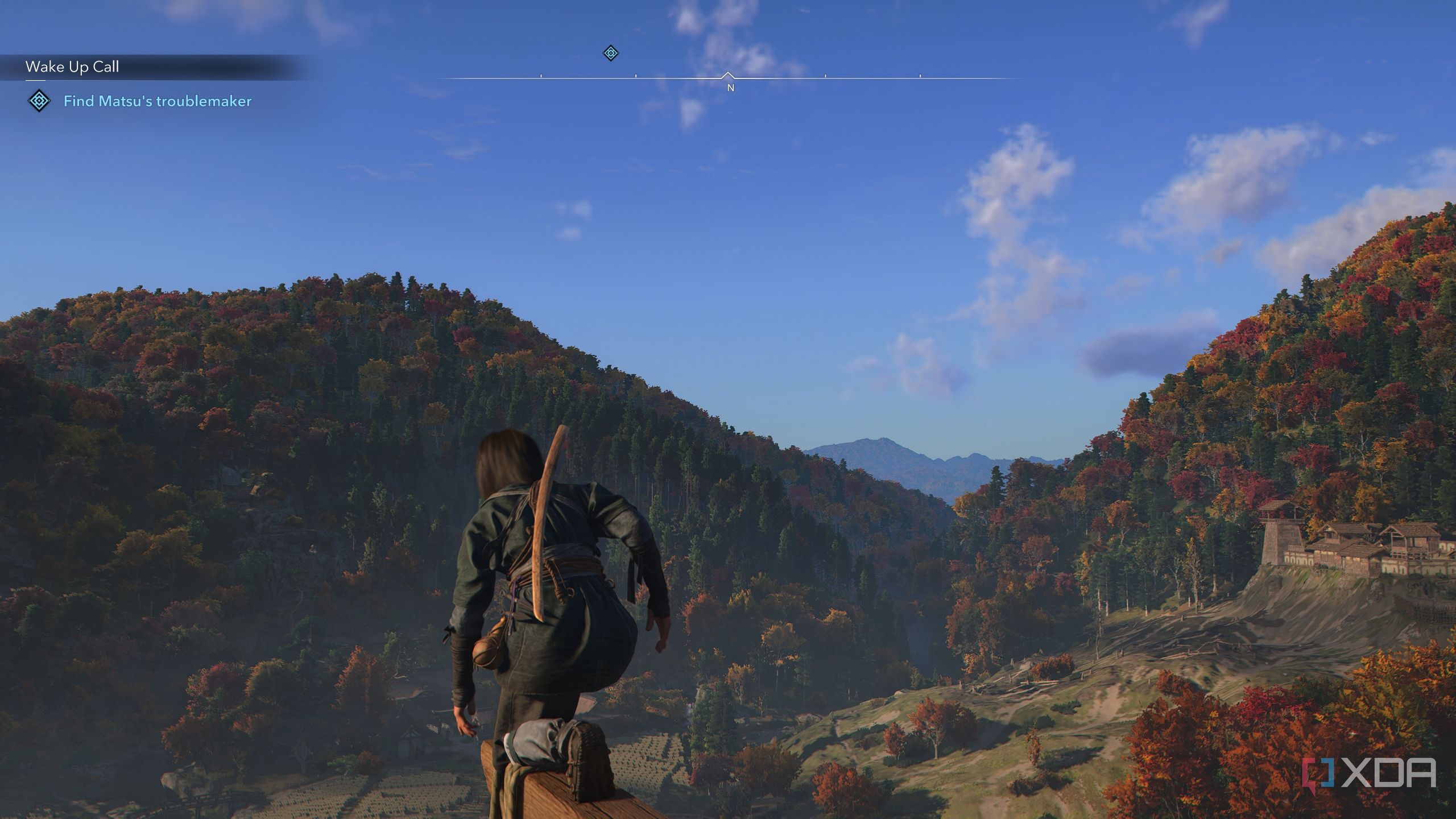 A screenshot from Assassin's Creed Shadows, showing Naoe, the female protagonist, perched atop a wooden beam, taking in the densely vegetated mountains.