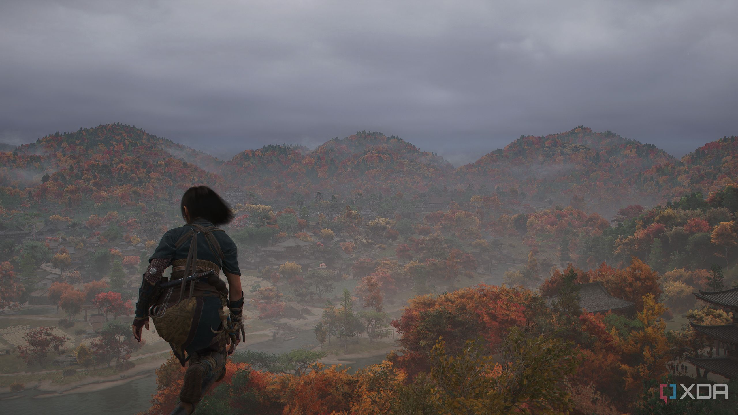 A screenshot from Assassin's Creed Shadows, showing Naoe, the female protagonist, perched atop somewhere high as the winds blow.