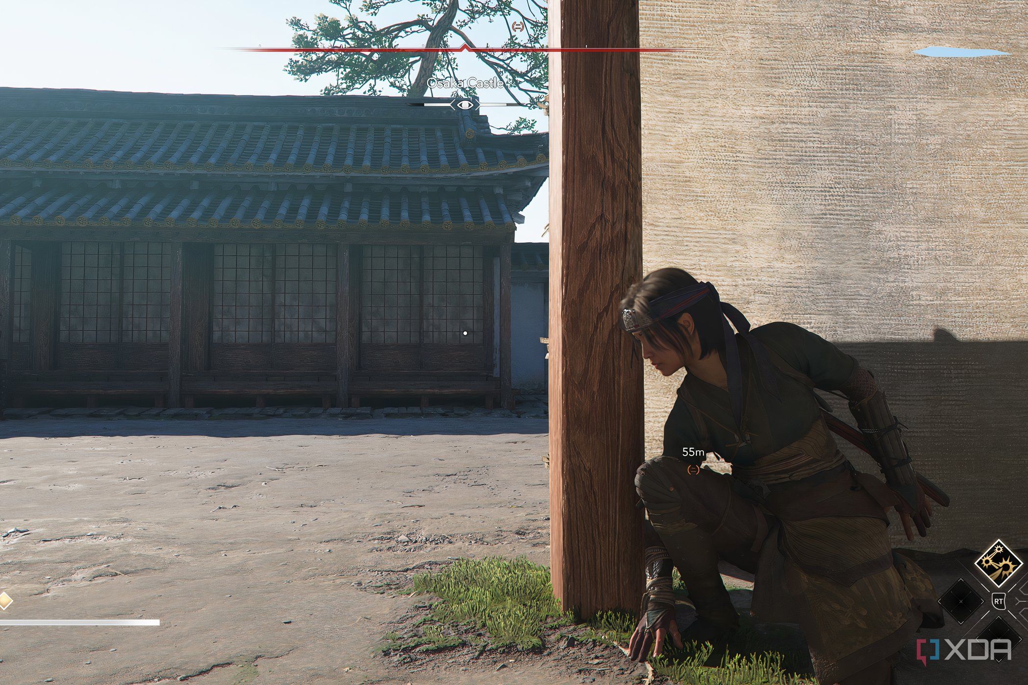 A screenshot from the game Assassin's Creed Shadows, showing Naoe, the protagonist, crouched behind a wall.