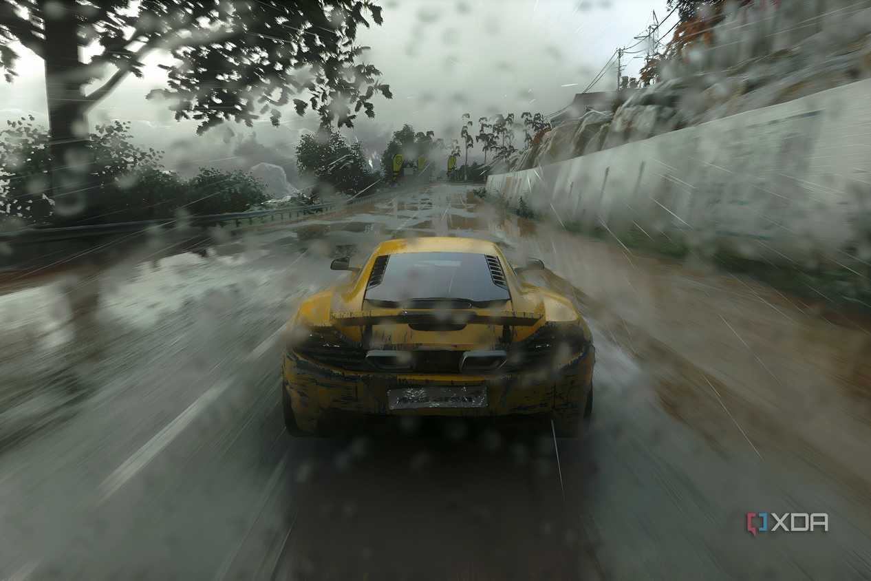 An image from the 2014 game Driveclub, showing the rear of a yellow McLaren as it races while the rain pours down heavily.