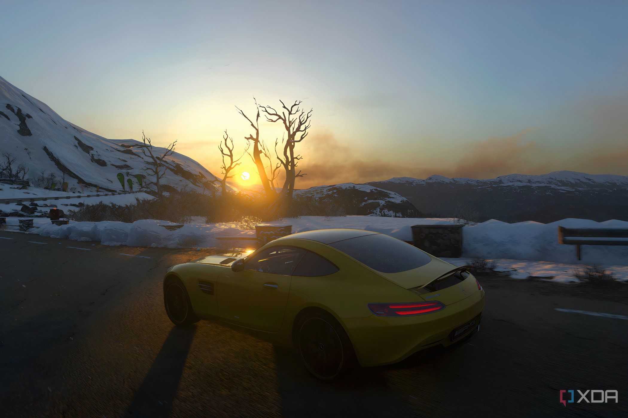 An image from the 2014 game Driveclub, showing a yellow Mercedes car frmo the side, driving in a snowy setting as the sun rises.