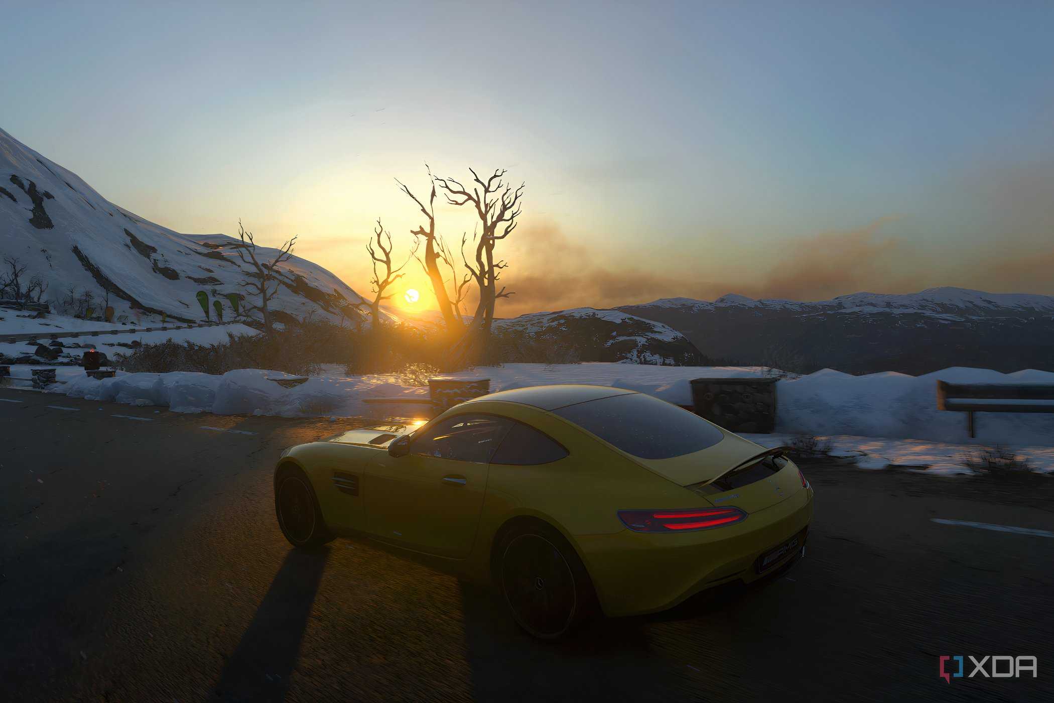 An image from the 2014 game Driveclub, showing a yellow Mercedes car frmo the side, driving in a snowy setting as the sun rises.