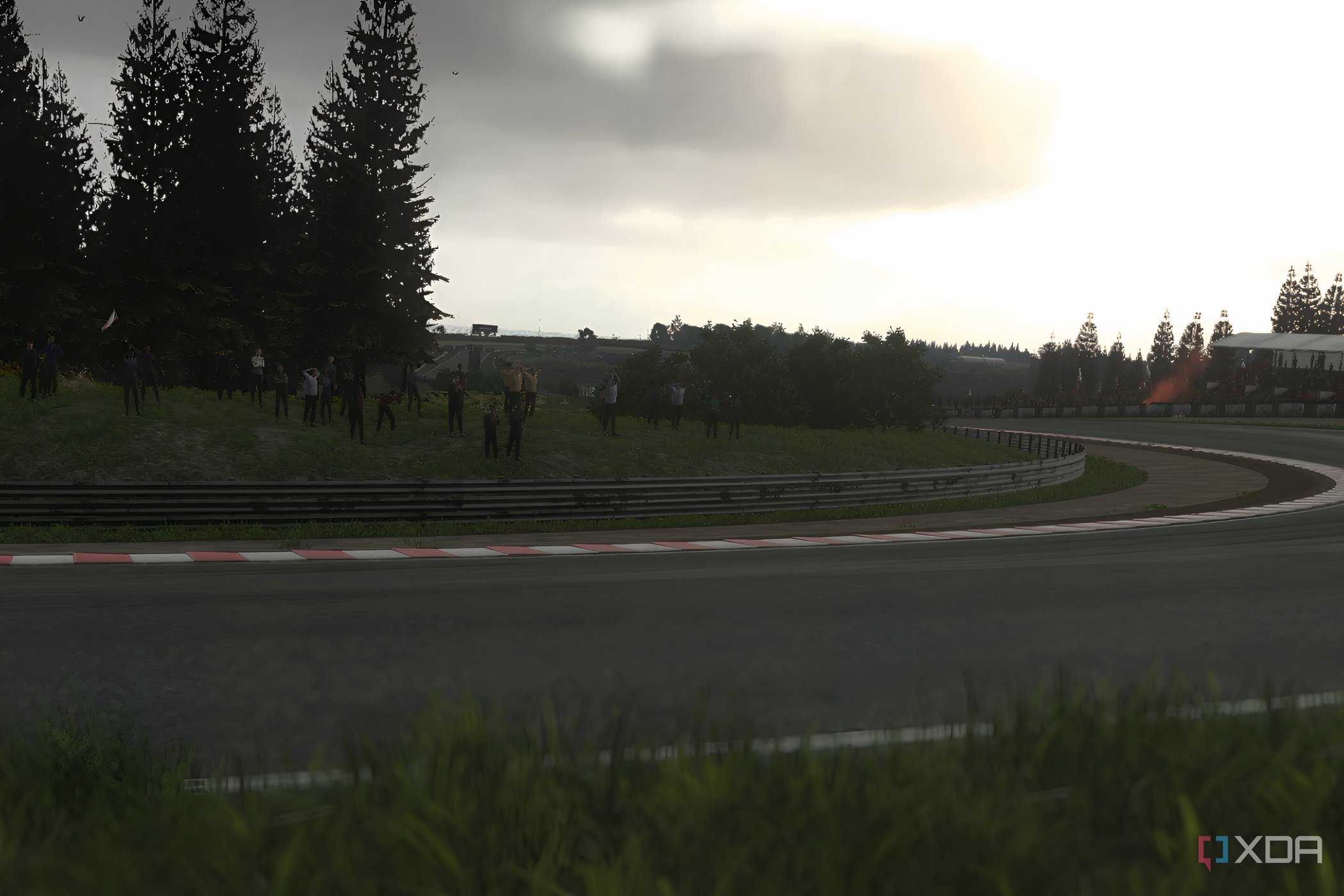 An image from the 2014 game Driveclub, showing a sunlit winding track with grass fields around it.