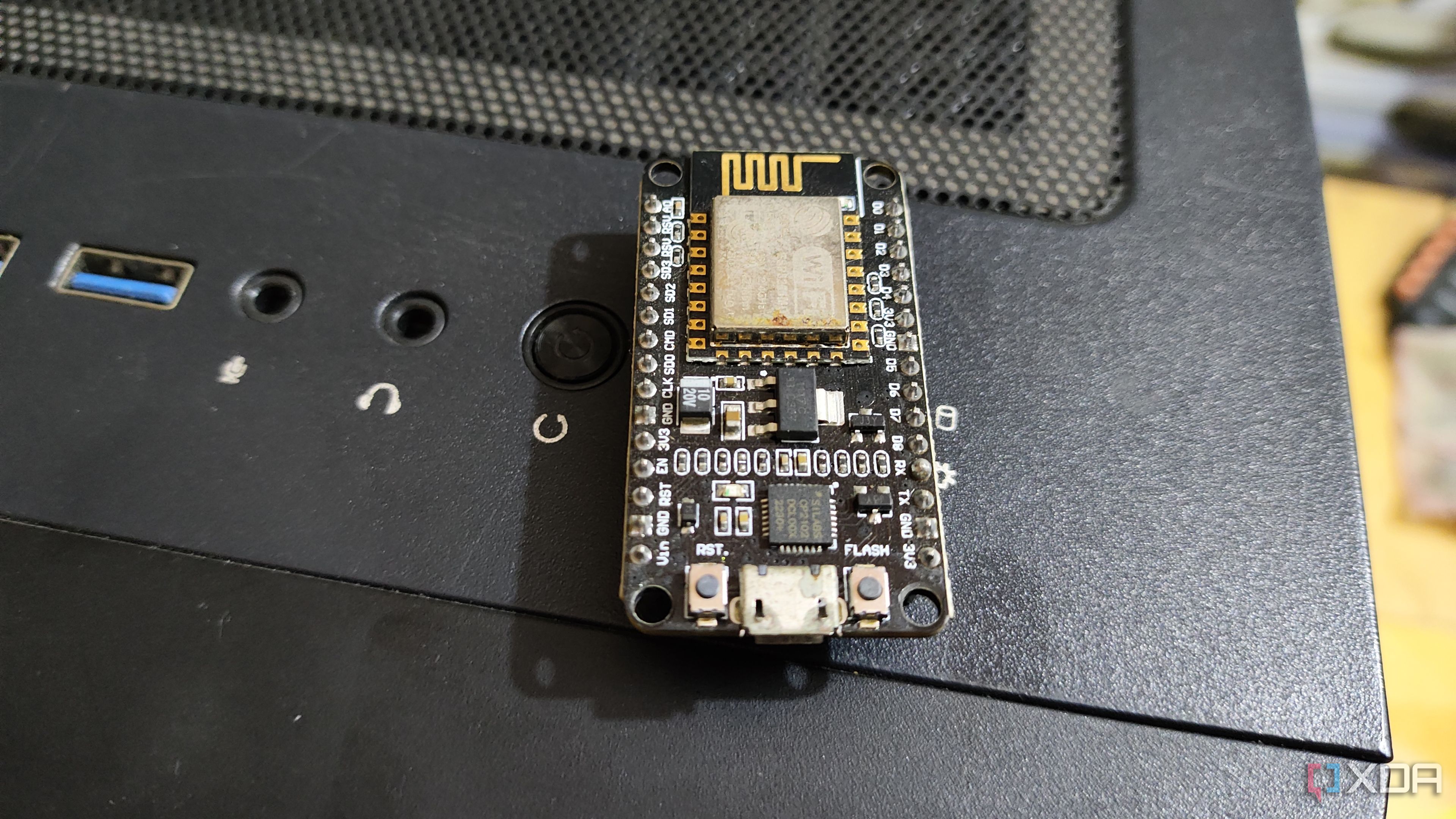 Un microcontrolador ESP8266 apoyado sobre un gabinete de PC