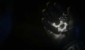 A screenshot from the game Gears 5, showing gear-shaped COG tags being held in a gloved hand.