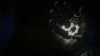 A screenshot from the game Gears 5, showing gear-shaped COG tags being held in a gloved hand.