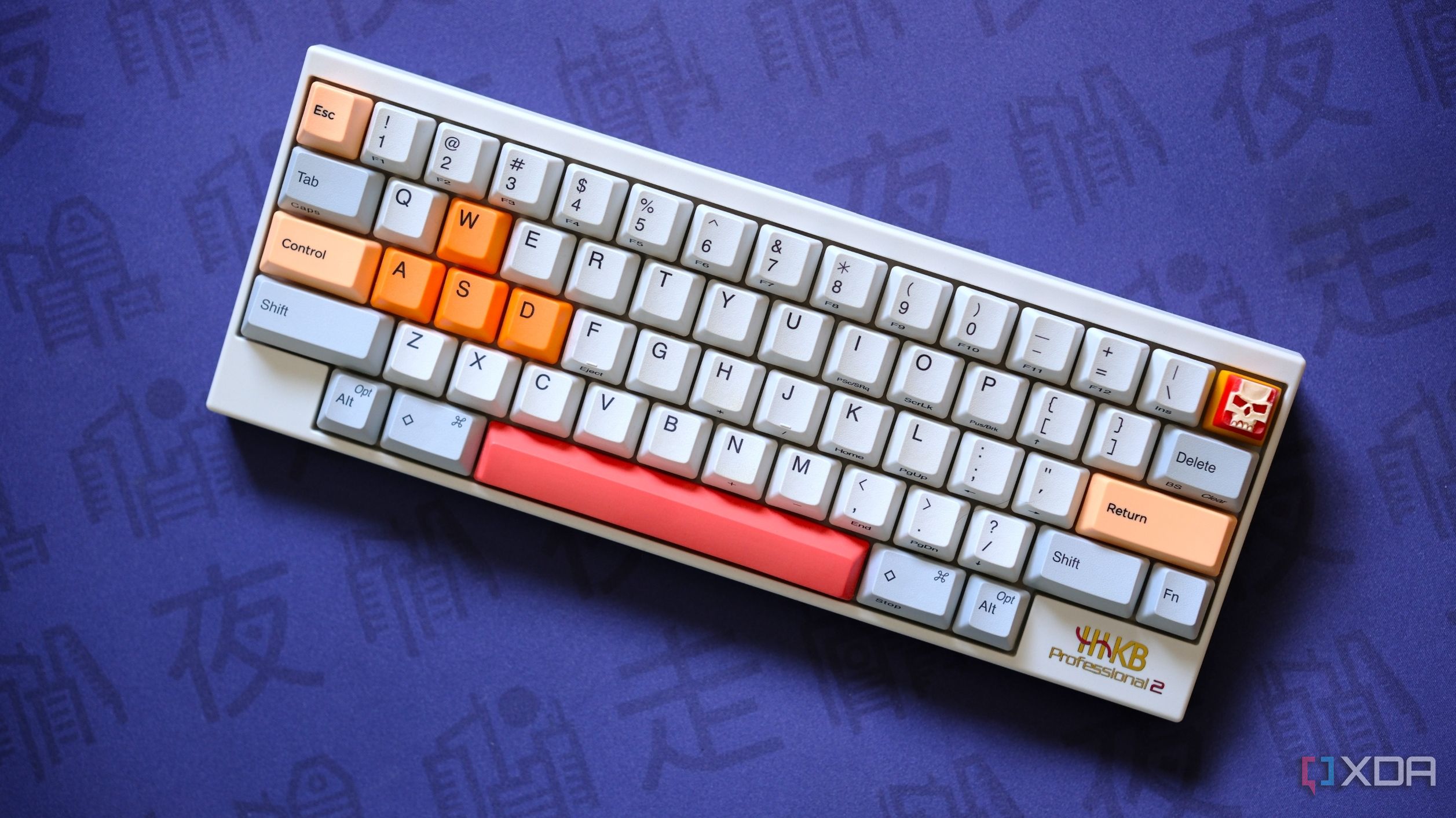 A white HHKB Professional 2 with orange accents on a purple deskmat