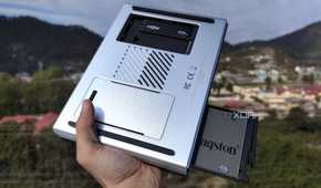 A person holding the LincPlus LincStation N2 NAS, with an SSD popping out of the NAS