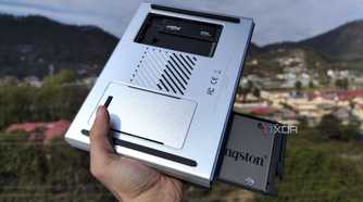 A person holding the LincPlus LincStation N2 NAS, with an SSD popping out of the NAS