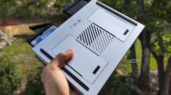 A person holding the LincPlus LincStation N2 NAS, with two drives popping out of the NAS
