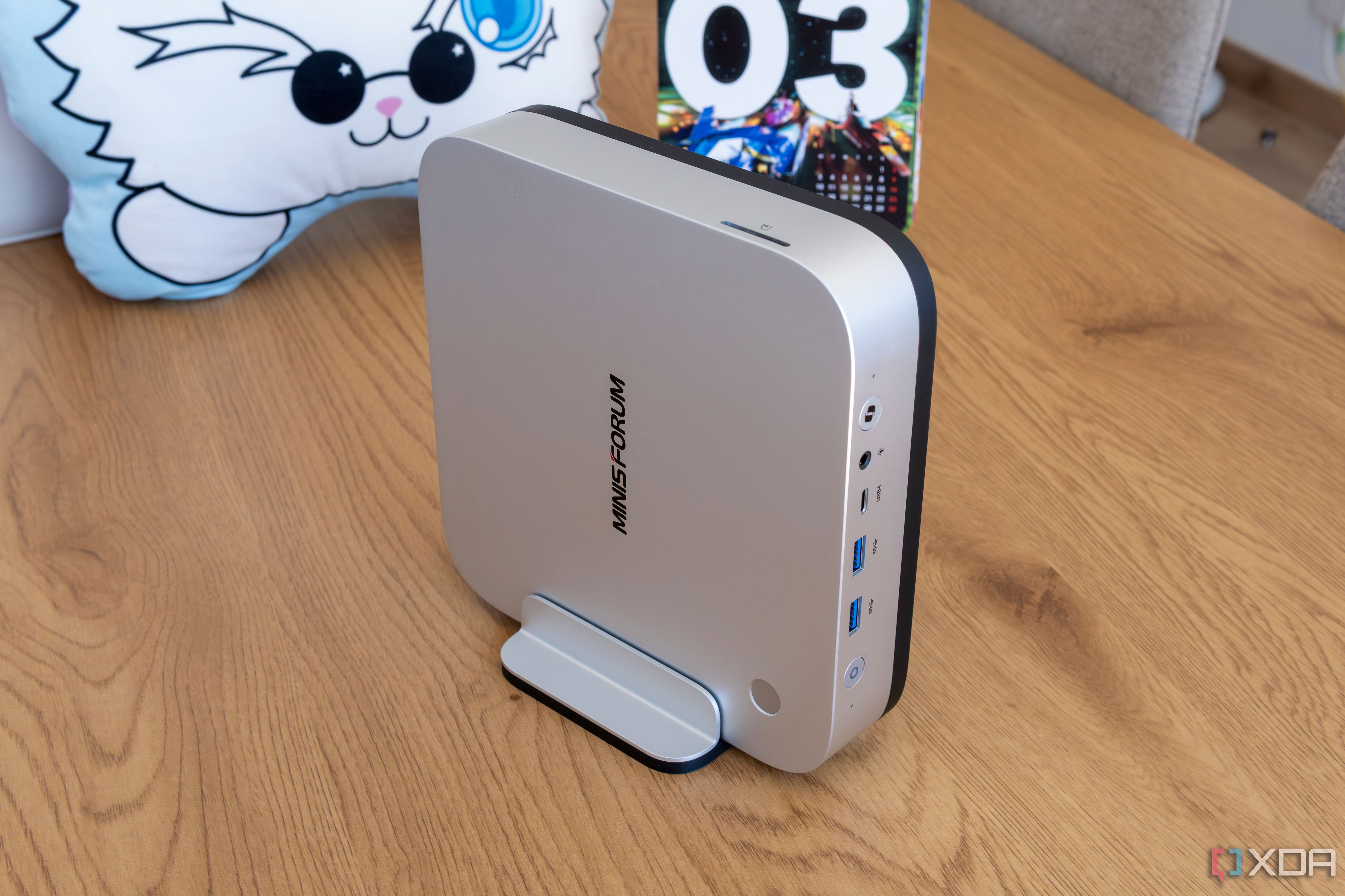 A Minisforum AI X1 Pro standing up using the included vertical stand