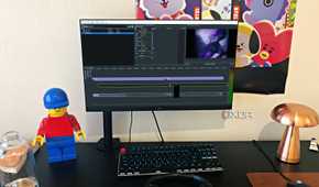 Olive video editor displayed on desktop PC, with lego, poster, and lamp in view