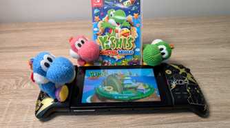 Three yarn Yoshis next to a Nintendo Switch featuring Yoshi's Crafted World