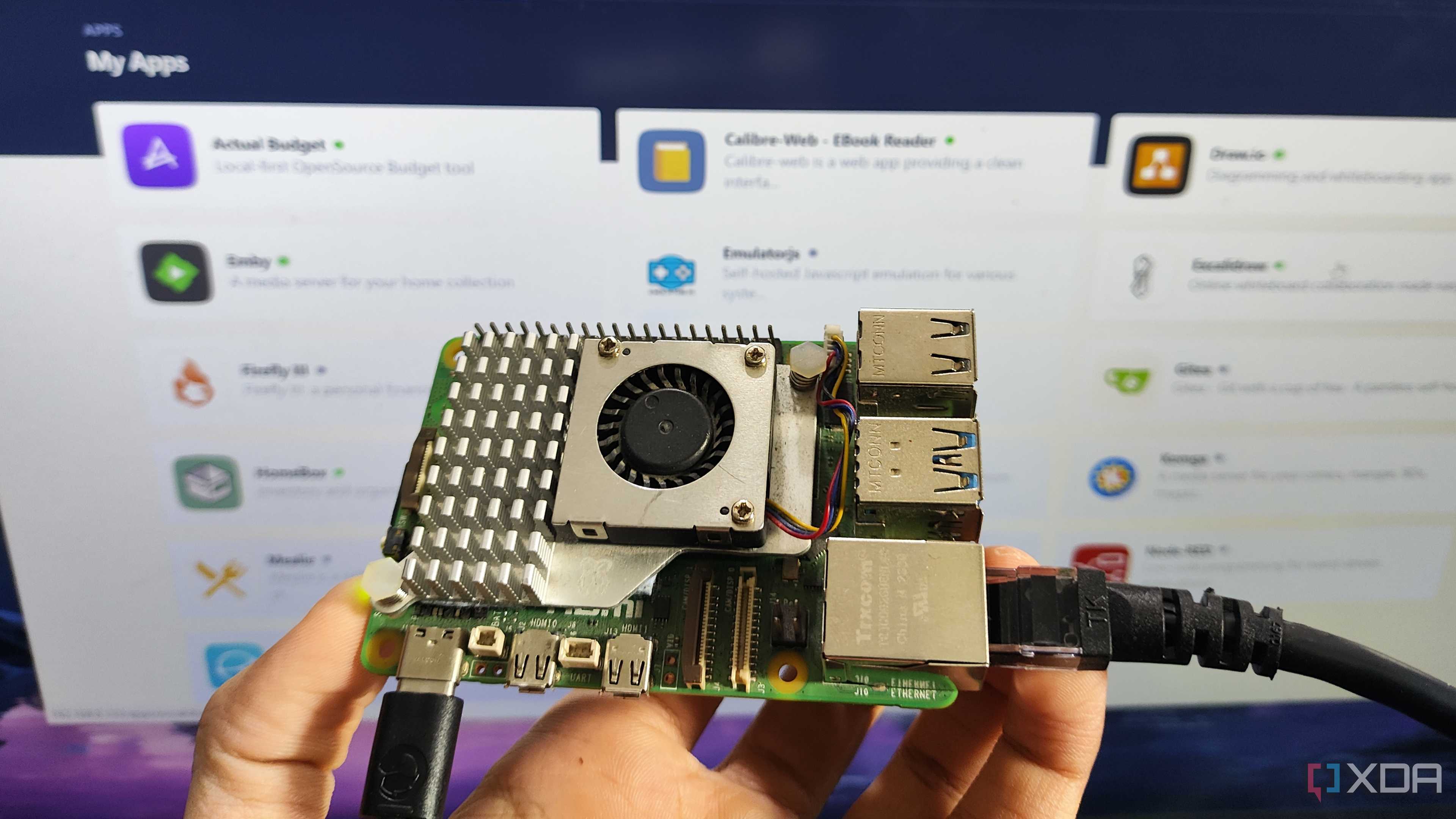 A person holding a Raspberry Pi in front of a screen displaying a RunTiPi server