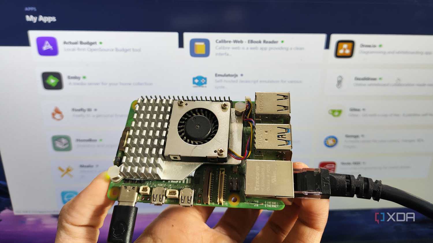 A person holding a Raspberry Pi in front of a screen displaying a RunTiPi server