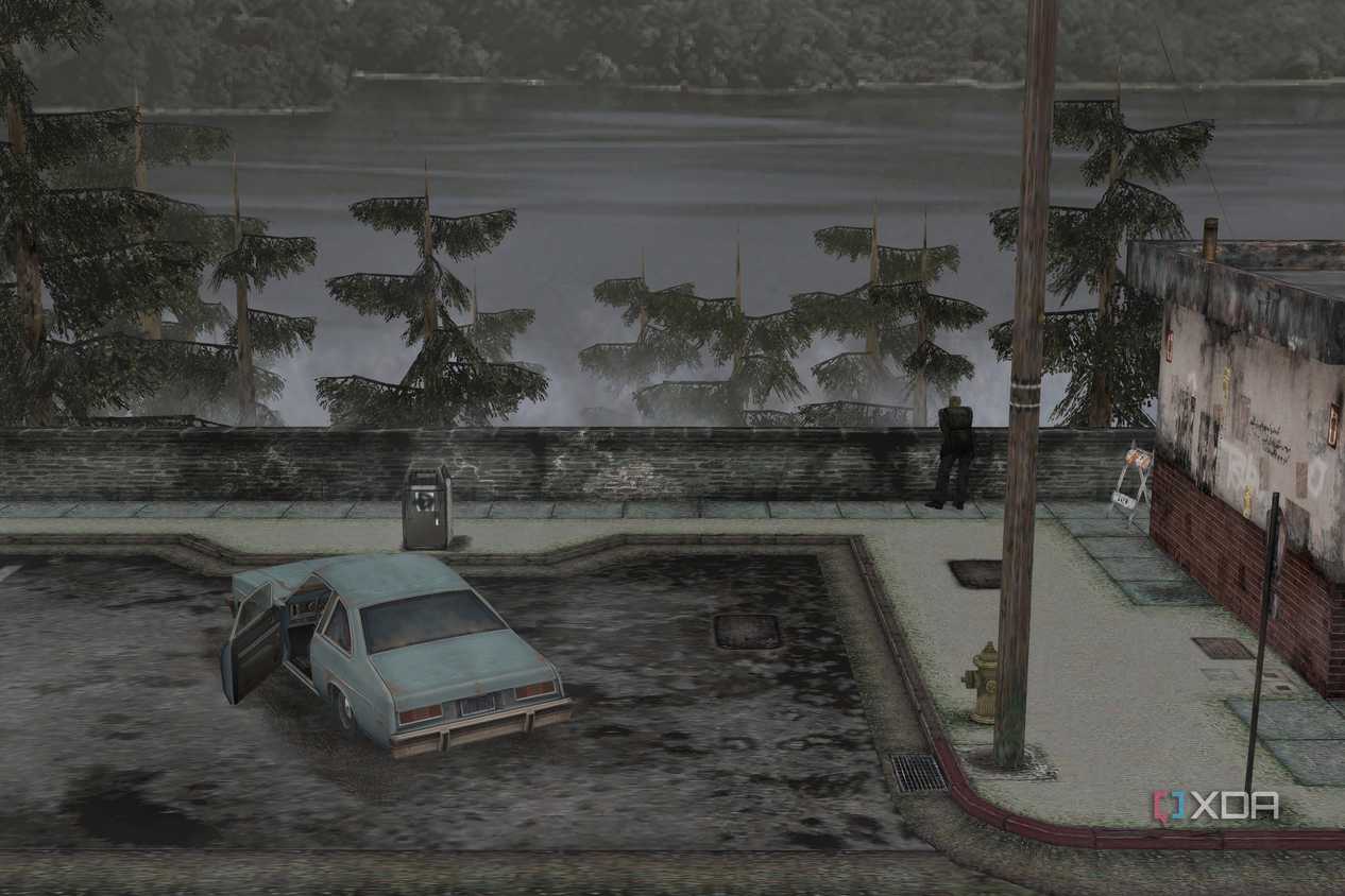 An in-game screenshot from the game Silent Hill 2, showing a large lake, a parking lot, and a blue coupe.