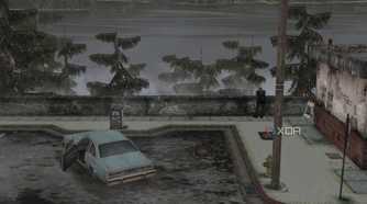 An in-game screenshot from the game Silent Hill 2, showing a large lake, a parking lot, and a blue coupe.
