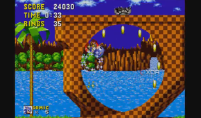 A screenshot of Sonic racing around a loop and collecting rings.