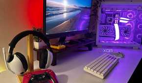 White Sony Inzone headsets with Cosmic Red DualSense controller sat on a desk with a gaming PC.