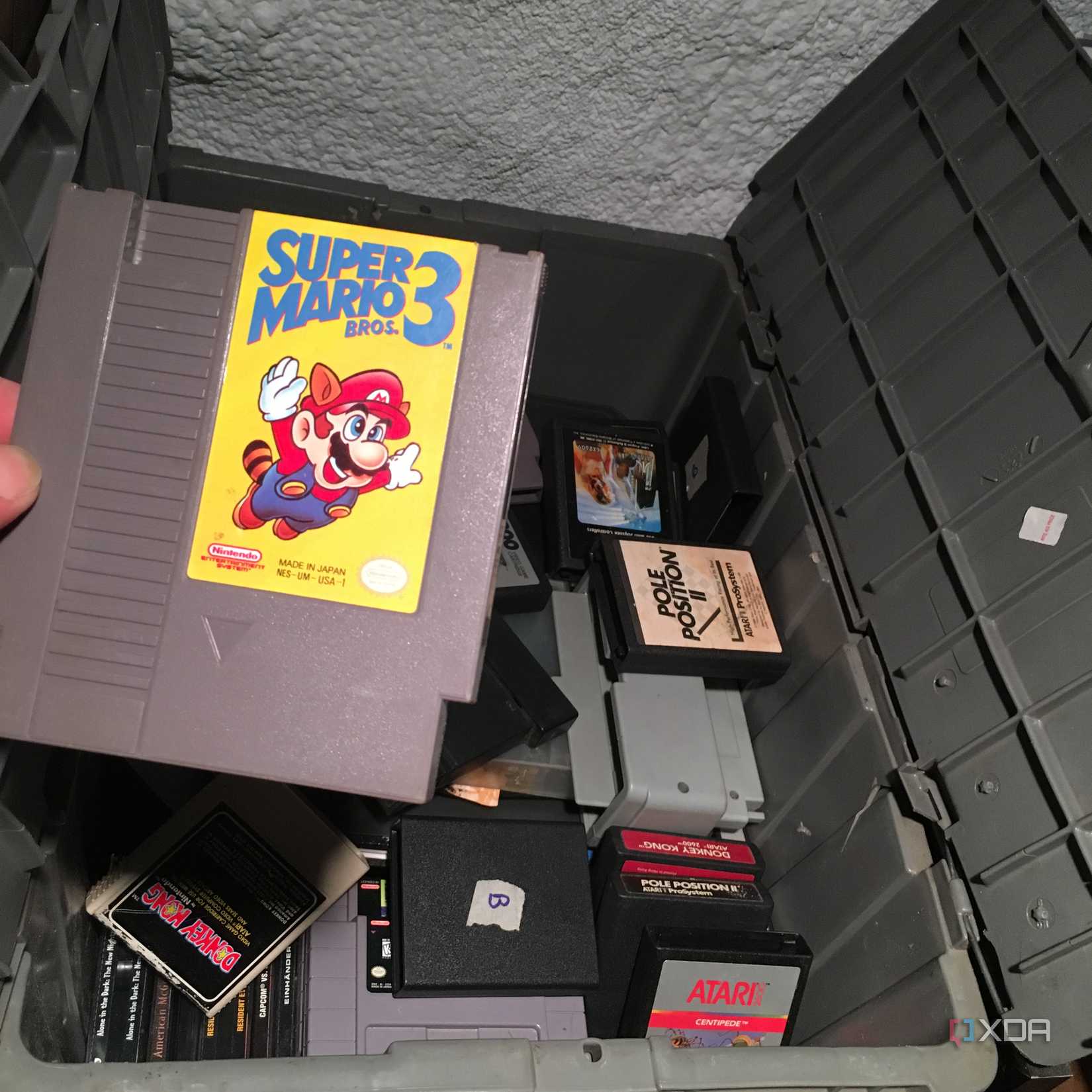 Super Mario Bros 3 being pulled out of an old box of retro games
