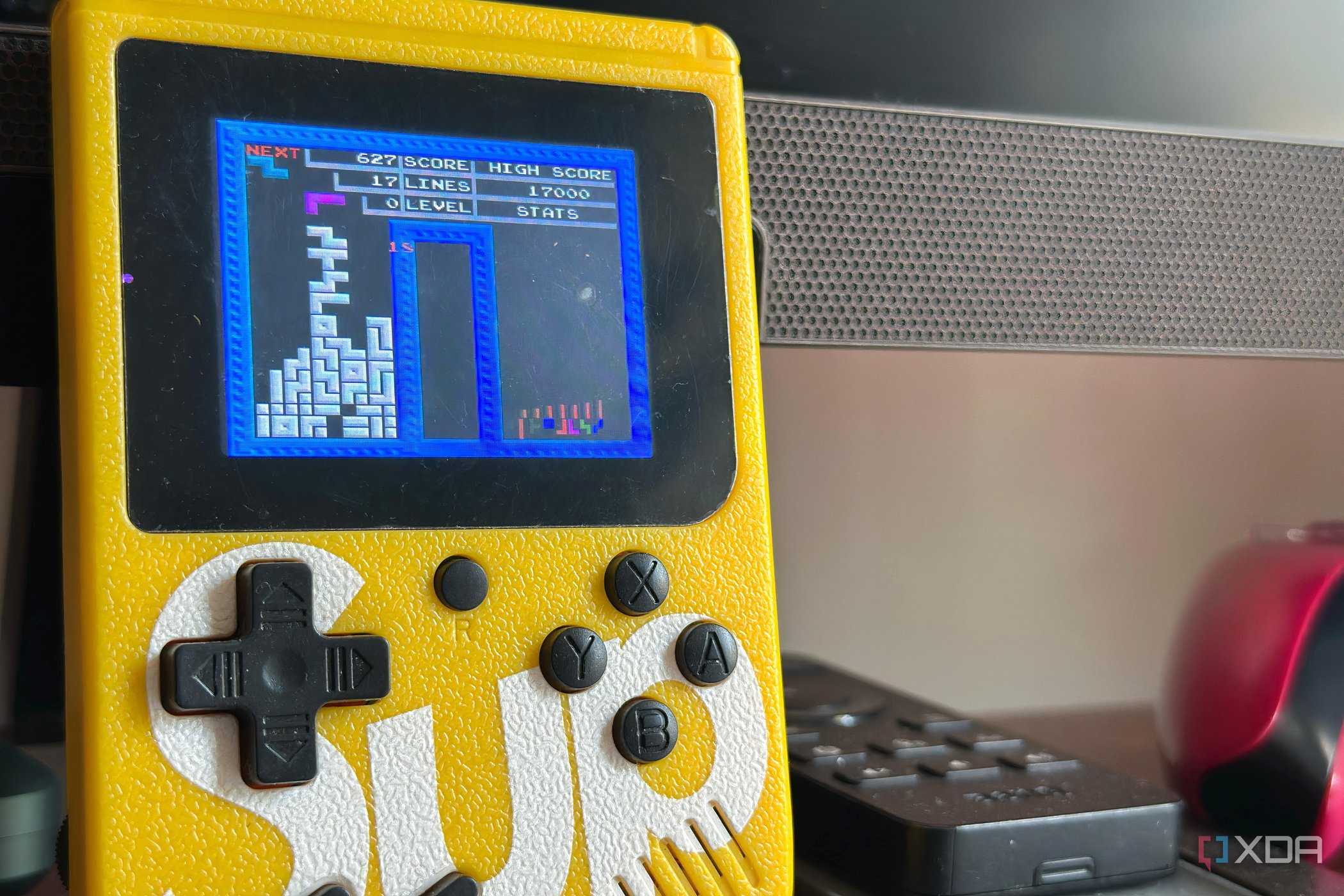 An image of a NES-rom Tetris game being played on a knock-off Game Boy.