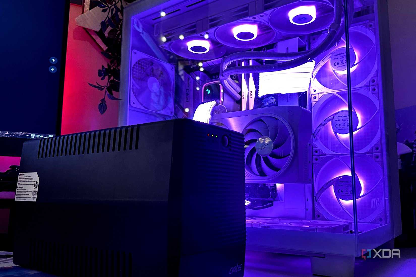 Un inversor UPS negro junto a un gabinete de PC para juegos