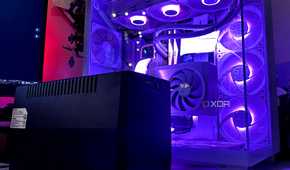 A black UPS inverter sitting next to a gaming PC cabinet