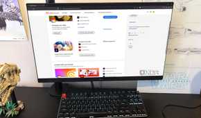 Adobe website displayed on desktop pc, with headphones, poster, and lego in view