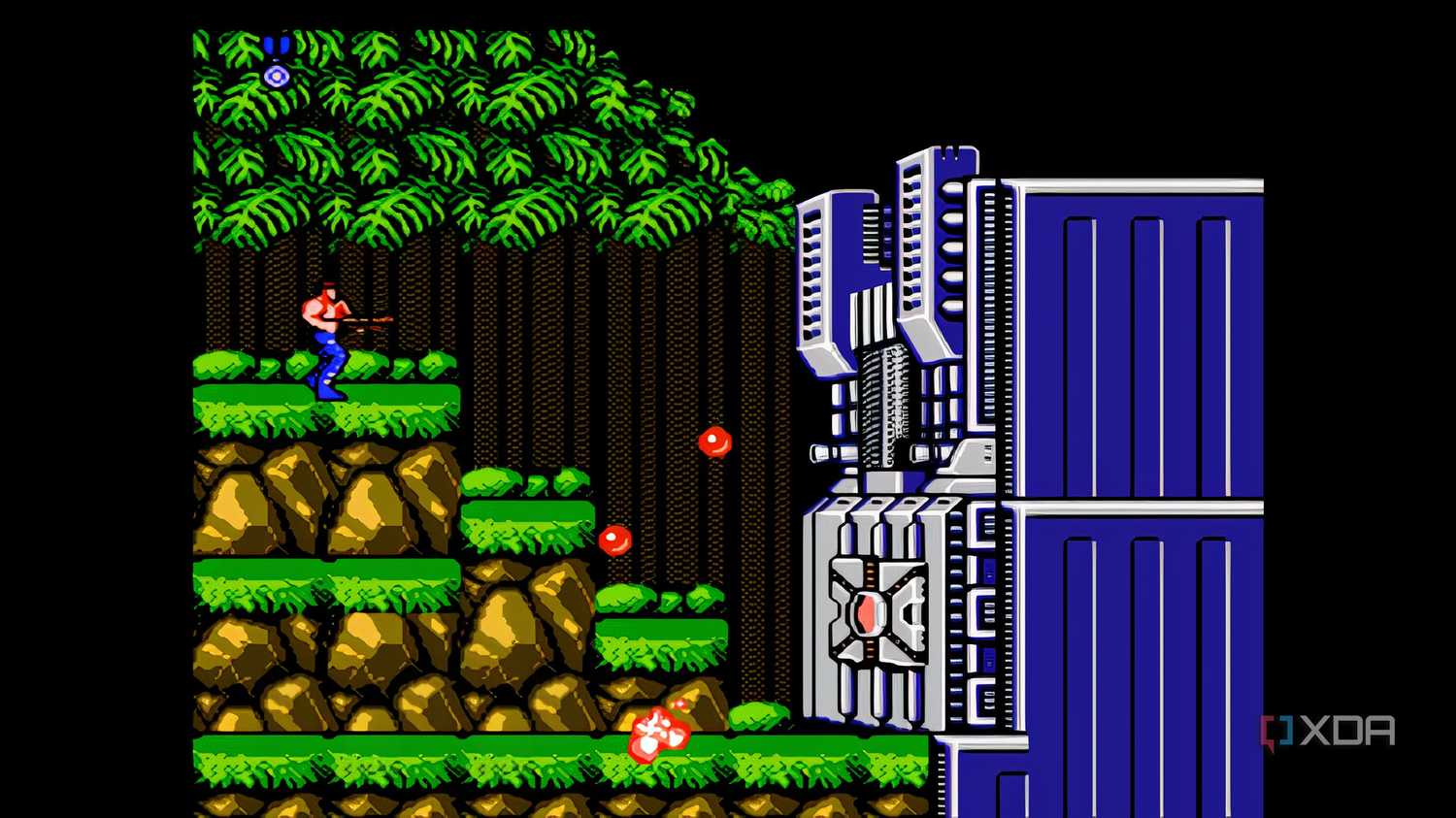 A screenshot from the game "Contra", showing the player character fighting against the first stage's boss.