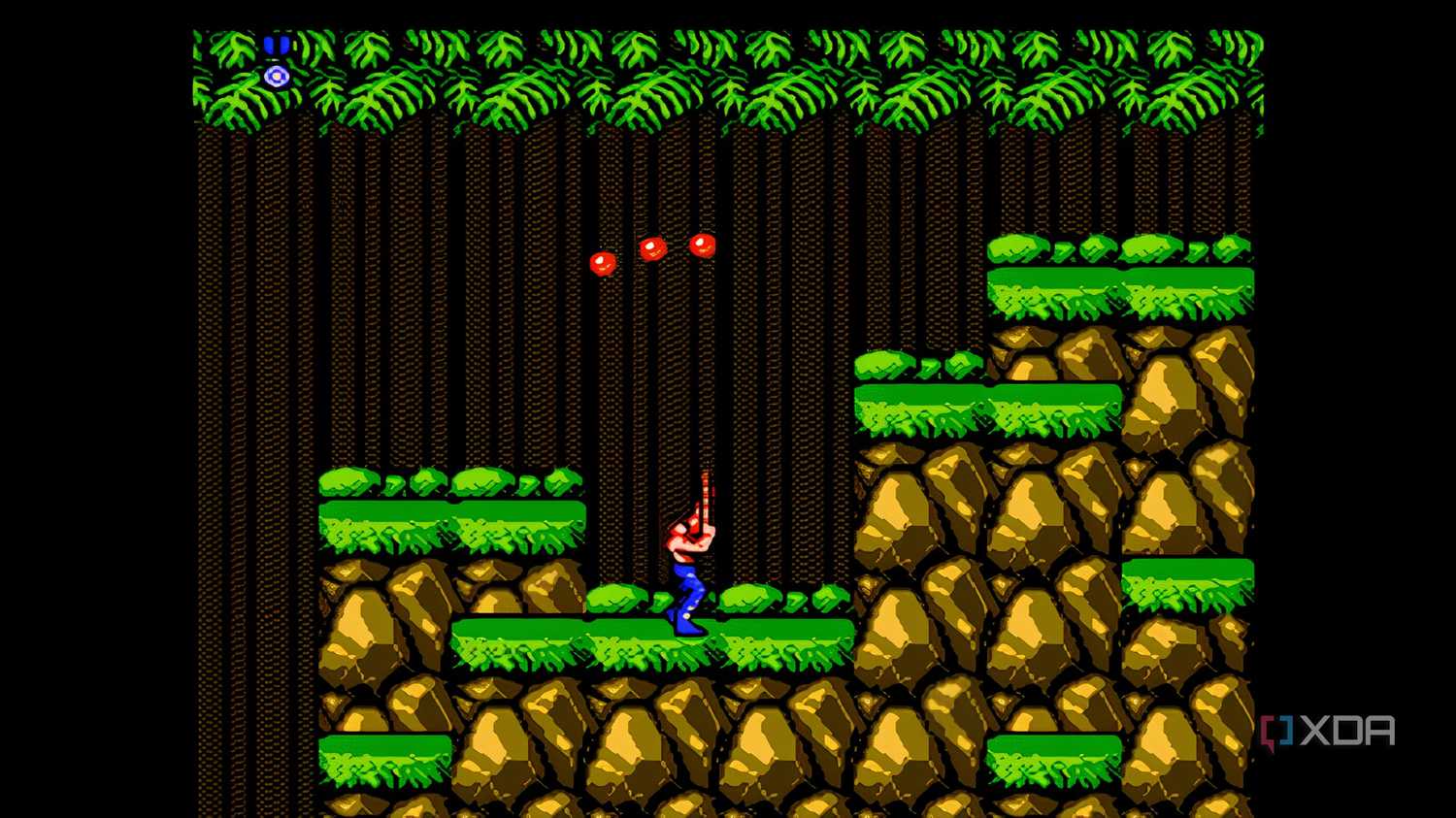 A screenshot from the game "Contra", showing the pler character shooting three bullets into the air above.