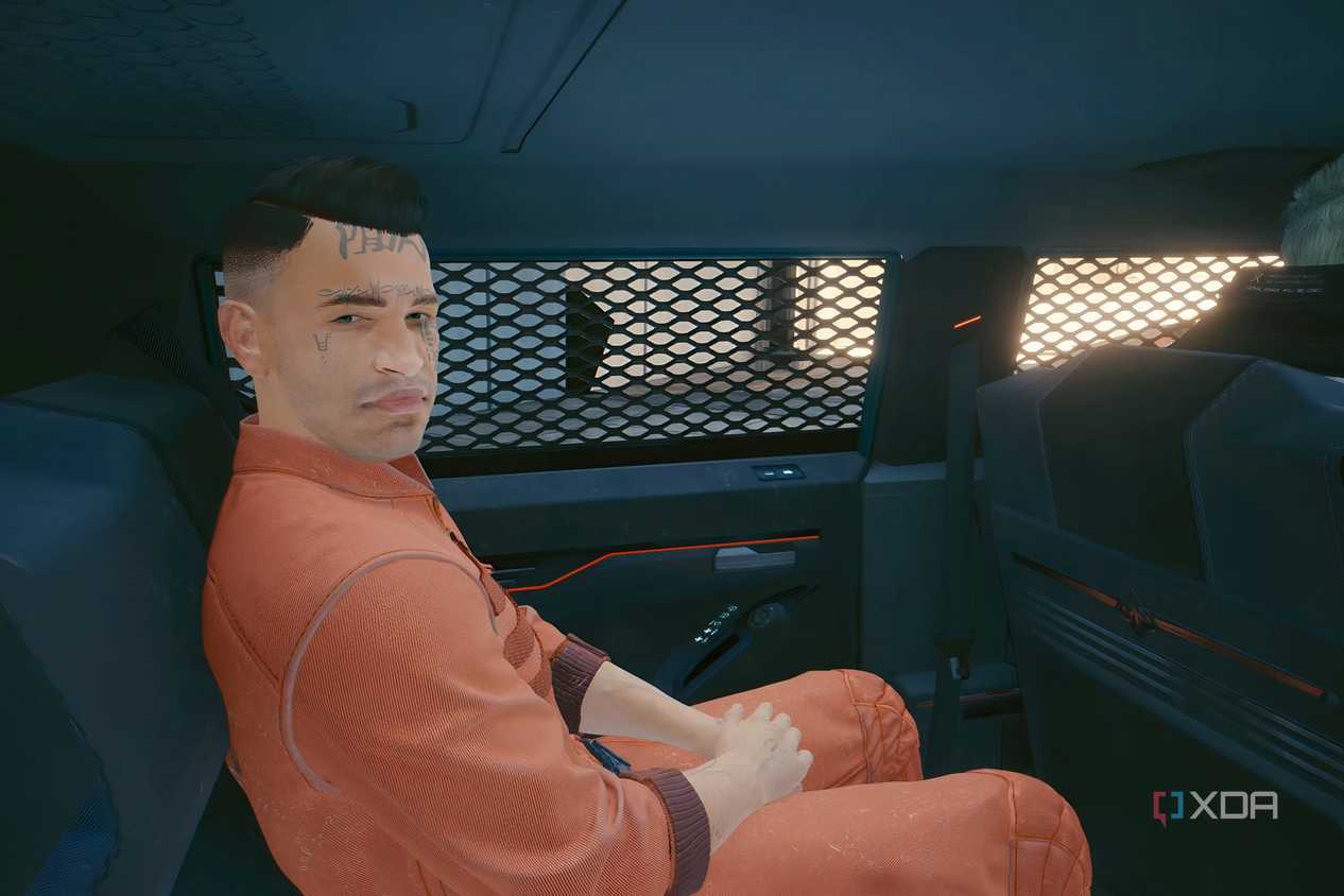 A screenshot from Cyberpunk 2077, showing a prisoner sitting inside a vehicle.