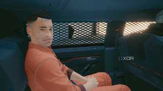 A screenshot from Cyberpunk 2077, showing a prisoner sitting inside a vehicle.