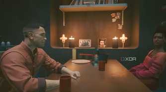 A screenshot from Cyberpunk 2077, showing two people sitting across from each other at a table.