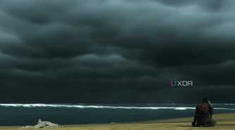 A screenshot from Ghost of Tsushima, showing Jin defeatedly sitting at Komoda beach, alone.