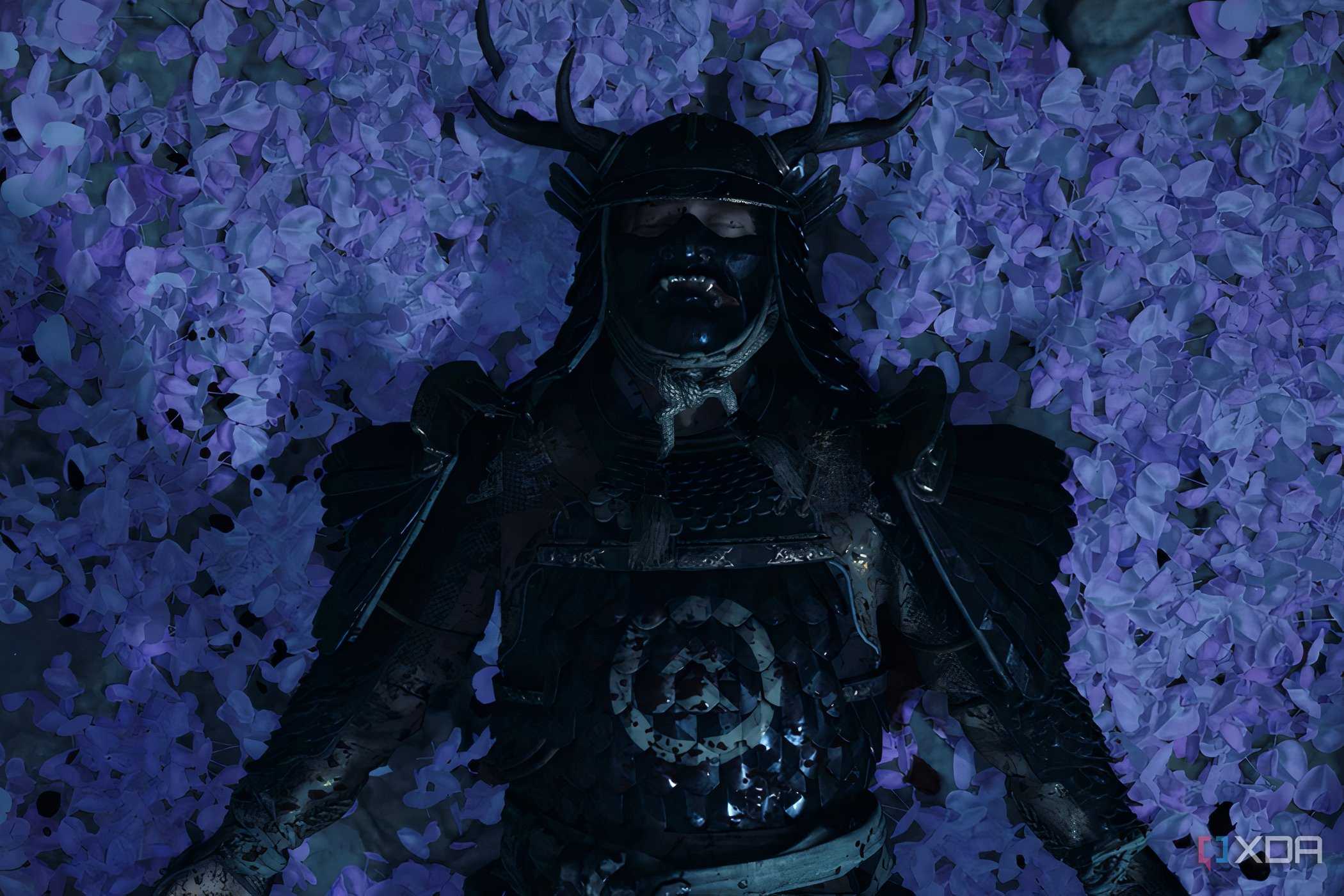 A screenshot from Ghost of Tsushima, showing Jin Sakai wearing Sakai armor and laying down on a bed of lilac petals.