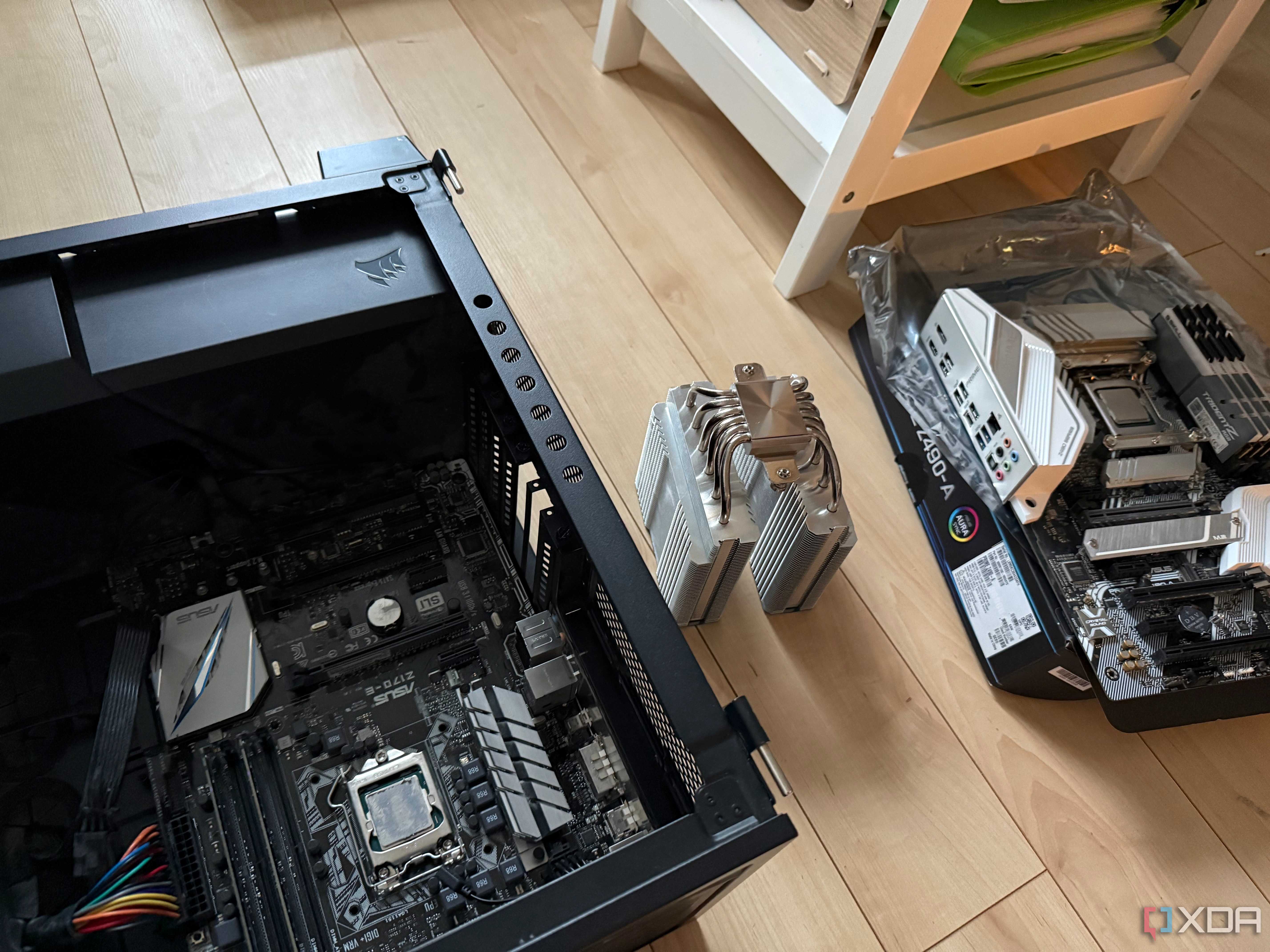 A photo of two motherboards and a CPU air cooler
