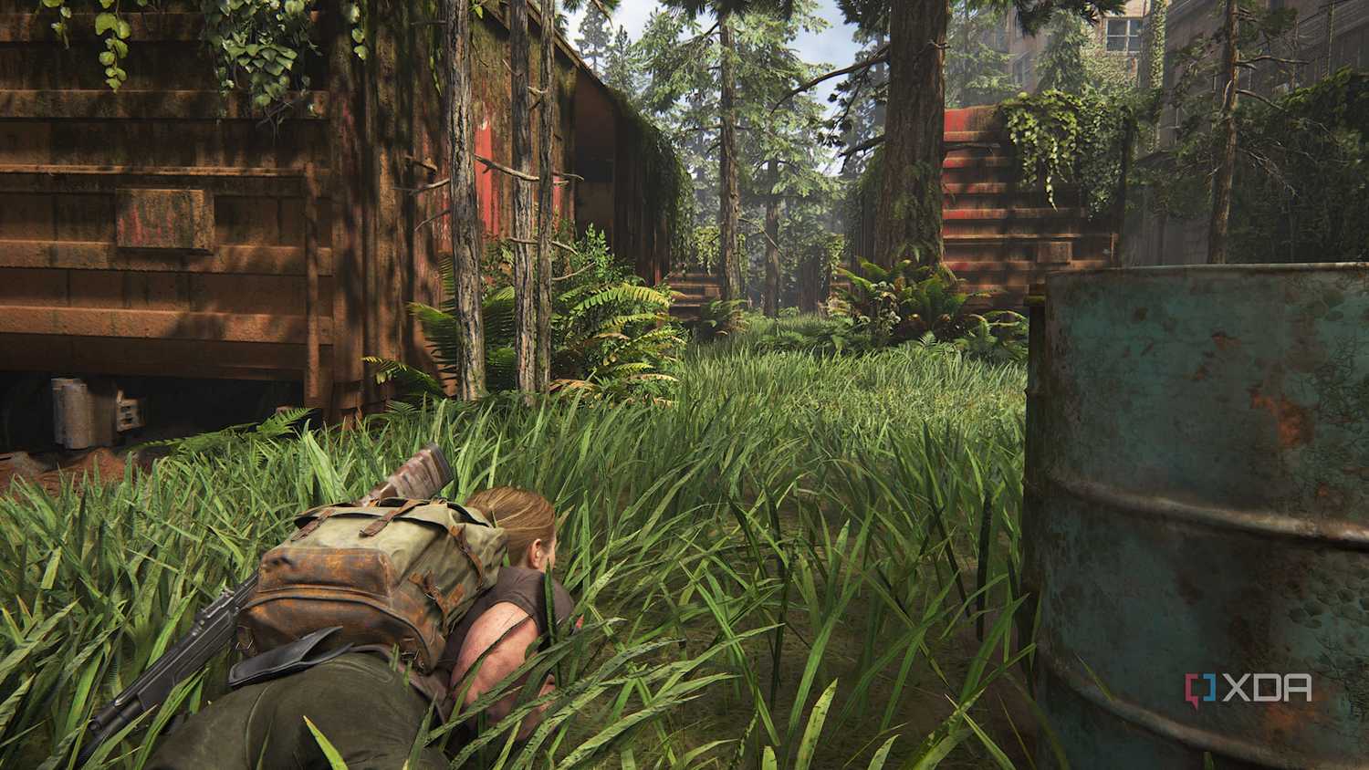 A screenshot from the game The Last of Us Part II, showing Abby prone in grass.