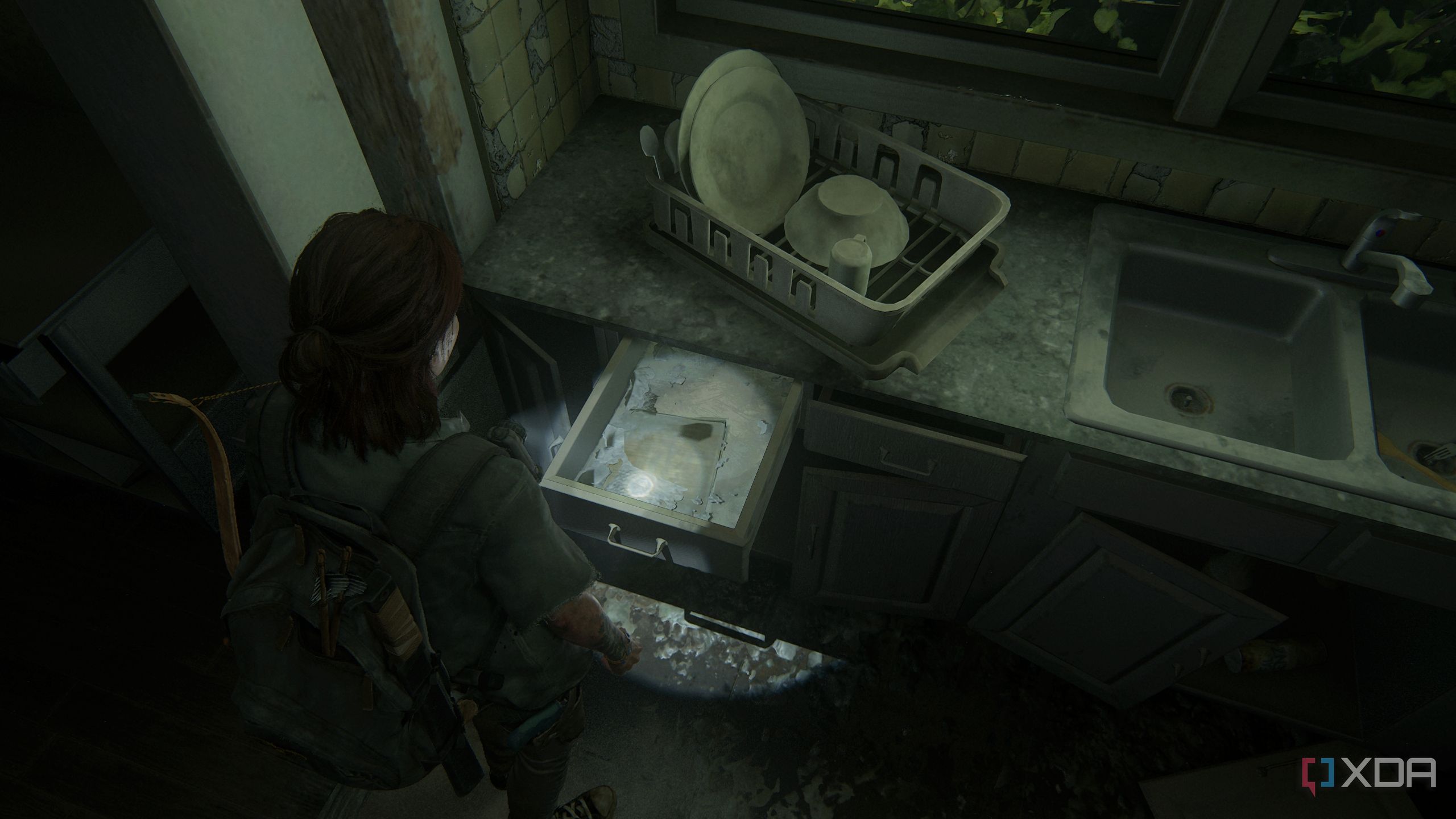 A screenshot from the game The Last of Us Part II, showing Ellie looking at empty drawers.