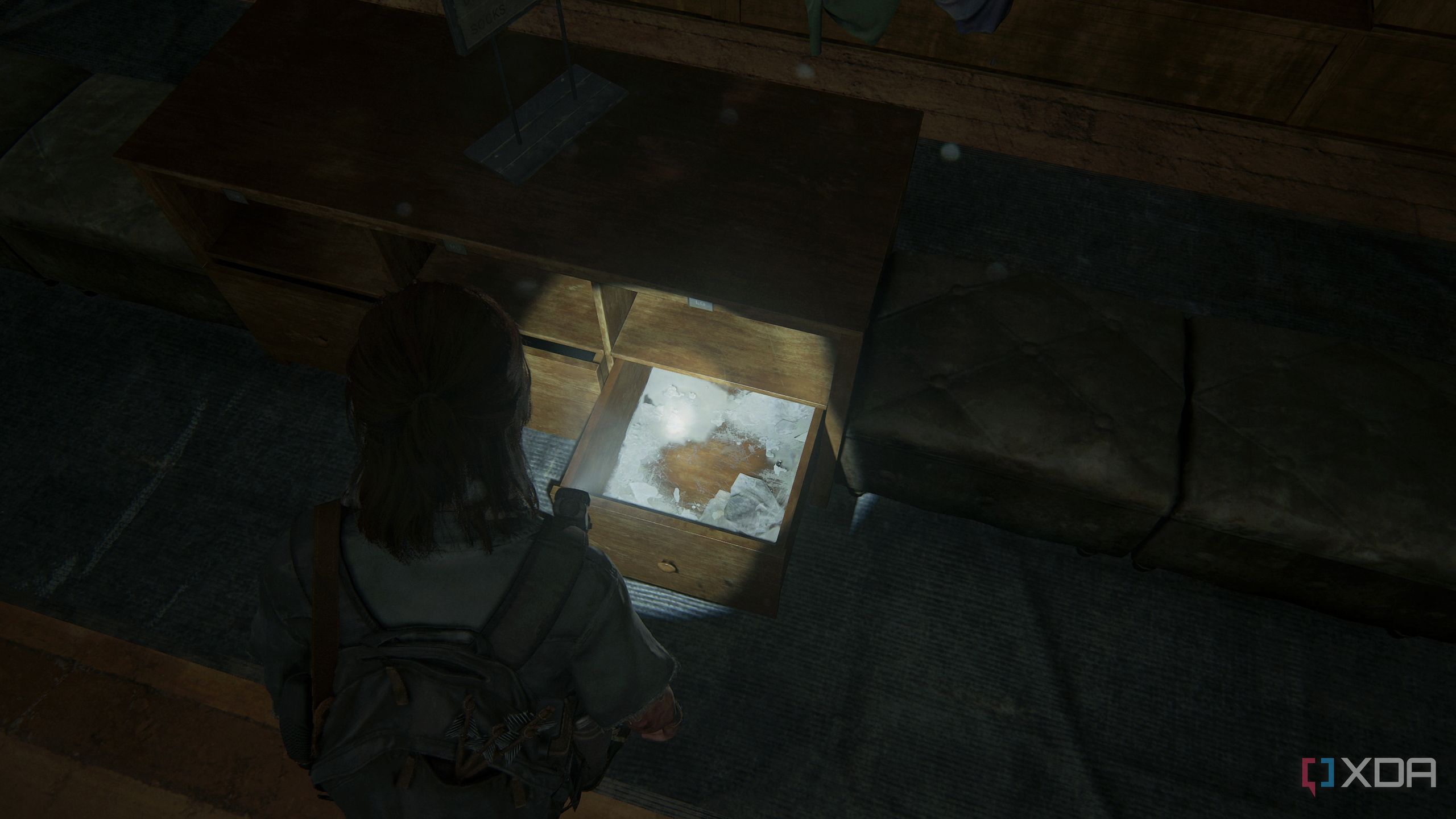 A screenshot from the game The Last of Us Part II, showing Ellie looking at an empty drawer.